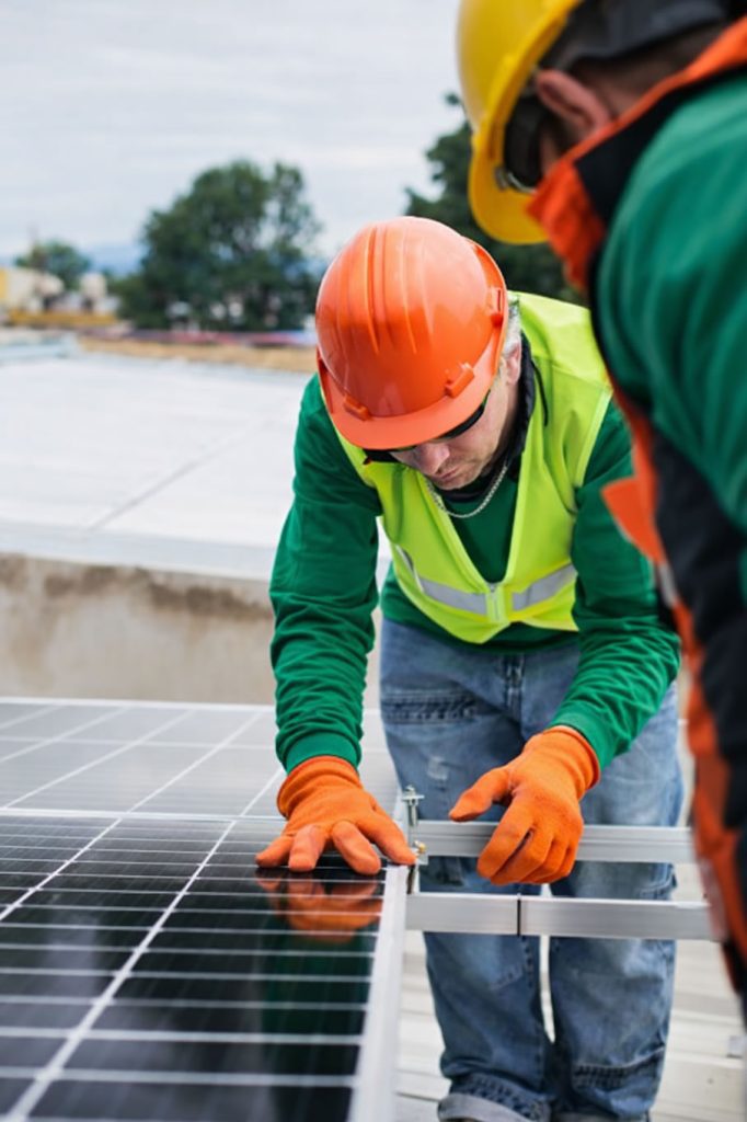 tradesman fixing solar panels fitting
